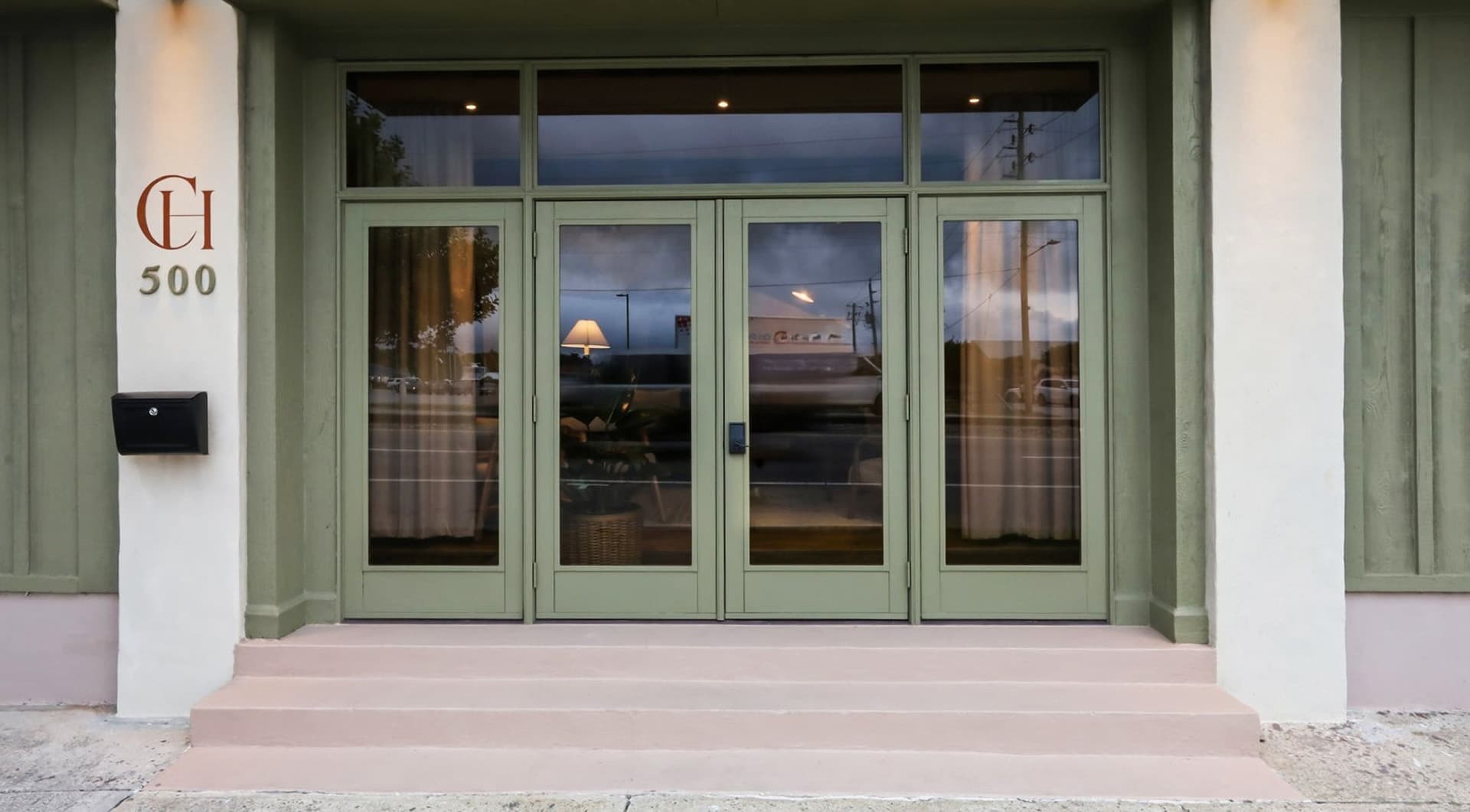 Front entrance of a building with green double doors and the number "500" displayed.